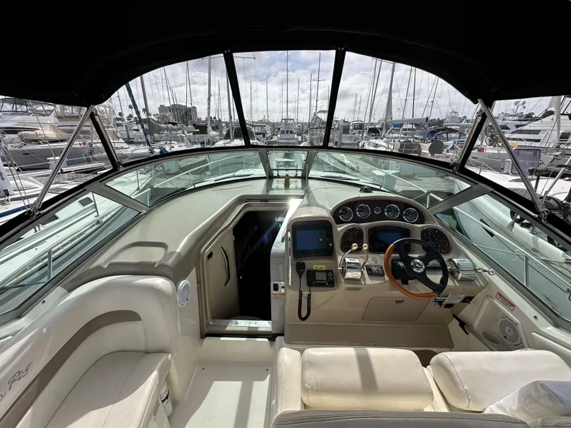 Slide: The Image of Interior view of 2003 Sea Ray 320 Sundancer yacht cockpit with marina background. - 15