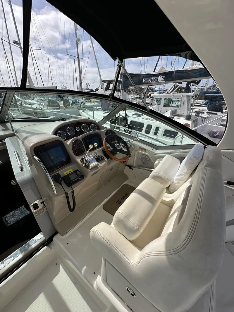 Slide: The Image of 2003 Sea Ray 320 Sundancer helm with modern controls and plush seating. - 16