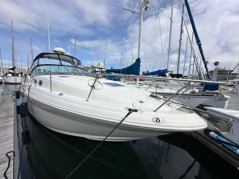 Slide: The Image of 2003 Sea Ray 320 Sundancer docked at a marina under a partly cloudy sky. - 2