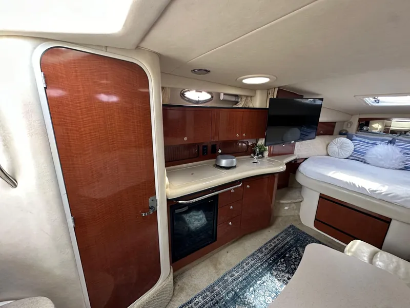 Slide: The Image of 2003 Sea Ray 320 Sundancer cabin interior with kitchenette, bed, and TV. - 29