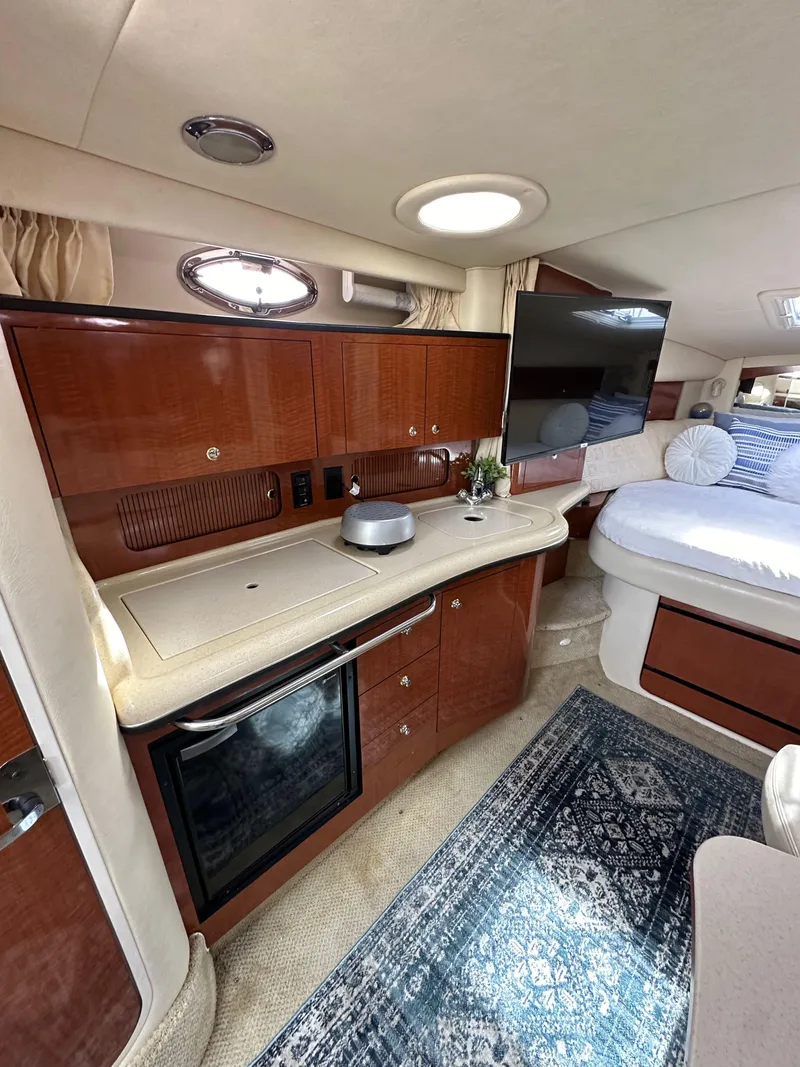 Slide: The Image of Interior of 2003 Sea Ray 320 Sundancer yacht with kitchenette and cozy sleeping area. - 31