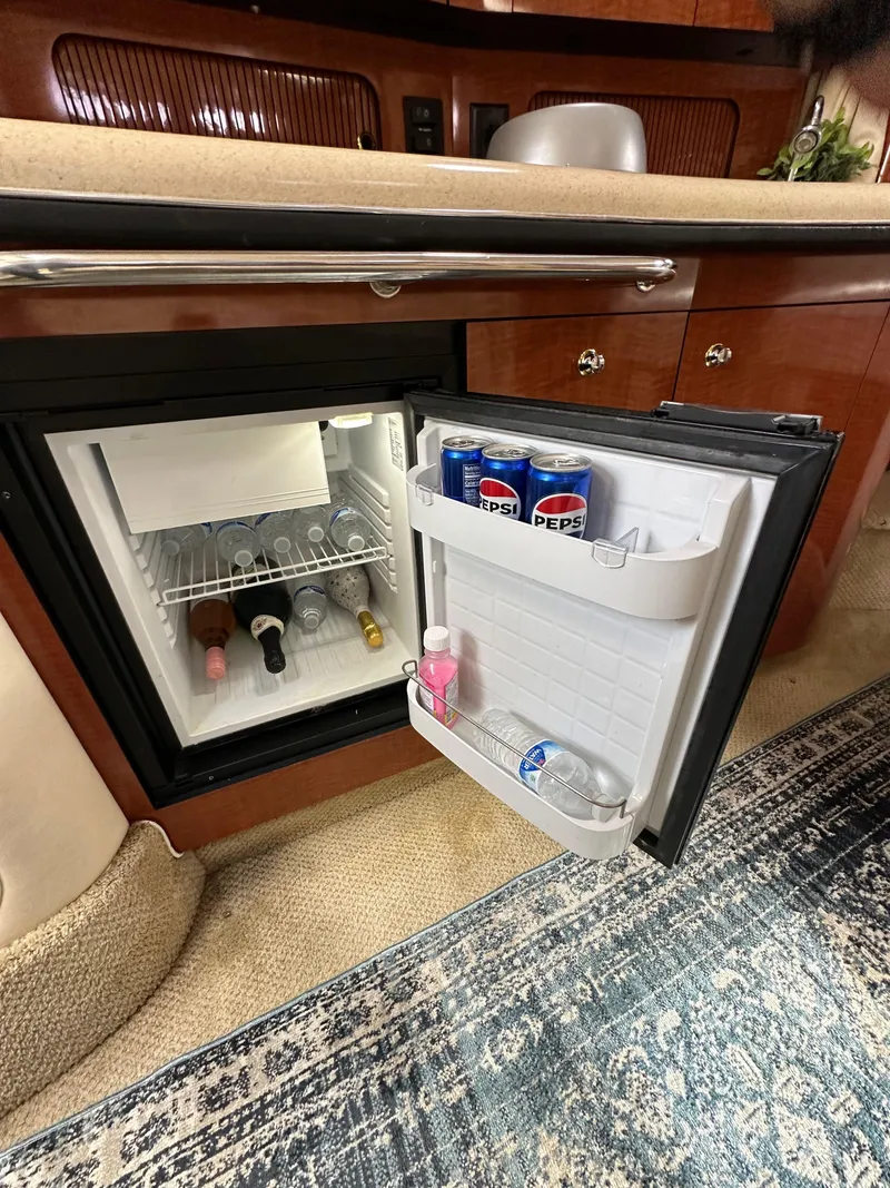 Slide: The Image of Mini fridge in 2003 Sea Ray 320 Sundancer yacht, stocked with drinks and wine bottles. - 33