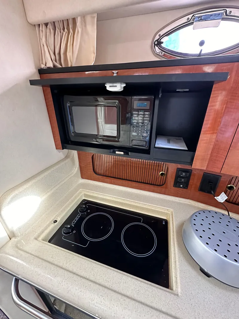 Slide: The Image of 2003 Sea Ray 320 Sundancer galley with microwave and electric stove. - 34