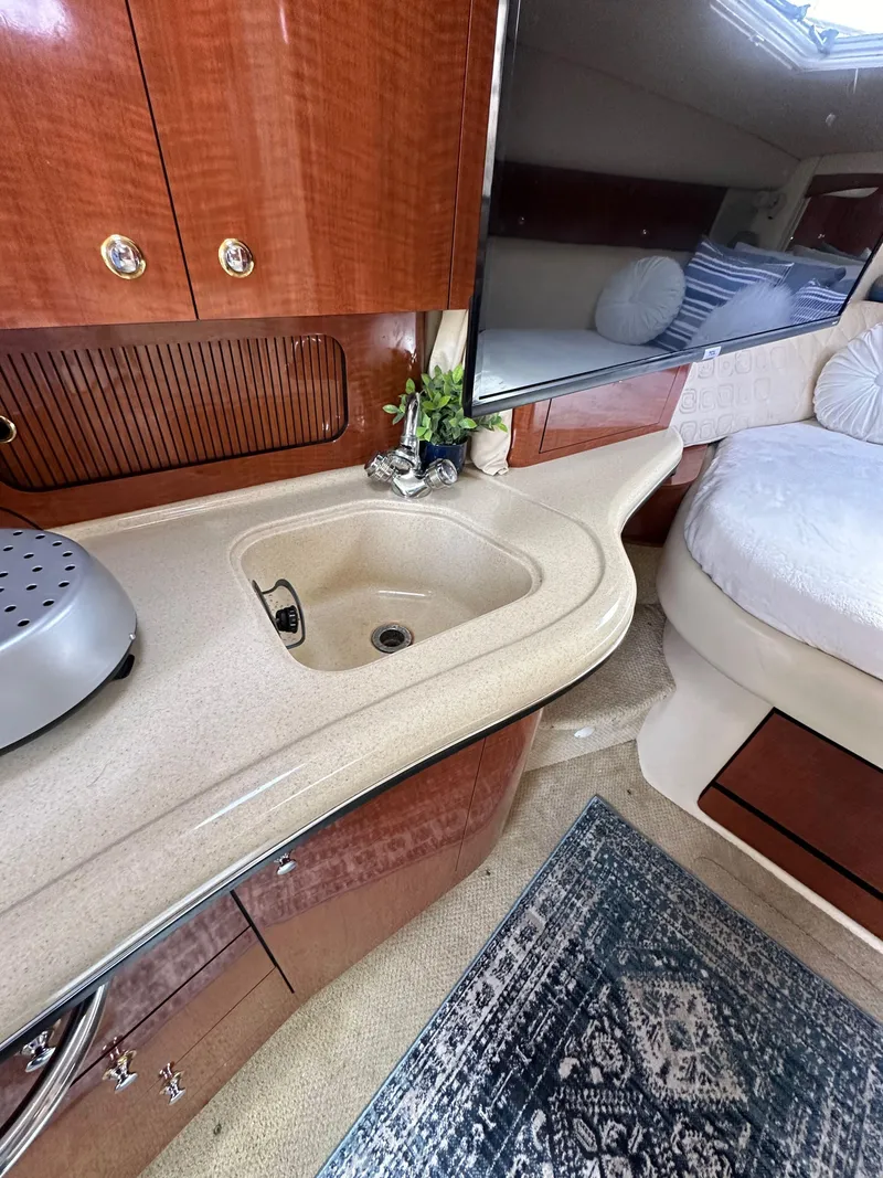 Slide: The Image of Interior of 2003 Sea Ray 320 Sundancer with sink, countertop, and cozy seating area. - 35