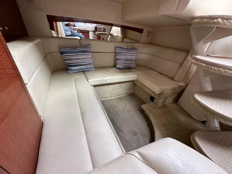 Slide: The Image of 2003 Sea Ray 320 Sundancer cabin interior with beige seating and striped cushions. - 45