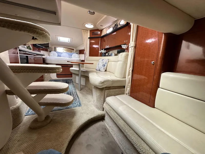 Slide: The Image of Interior of 2003 Sea Ray 320 Sundancer yacht with plush seating and elegant wood finishes. - 46