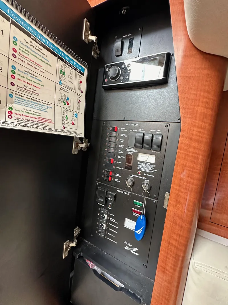 Slide: The Image of Electrical panel inside 2003 Sea Ray 320 Sundancer boat, featuring switches and controls. - 47