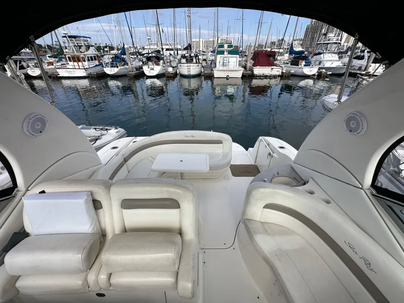 Slide: The Image of 2003 Sea Ray 320 Sundancer interior with marina view, featuring plush seating and elegant design. - 49