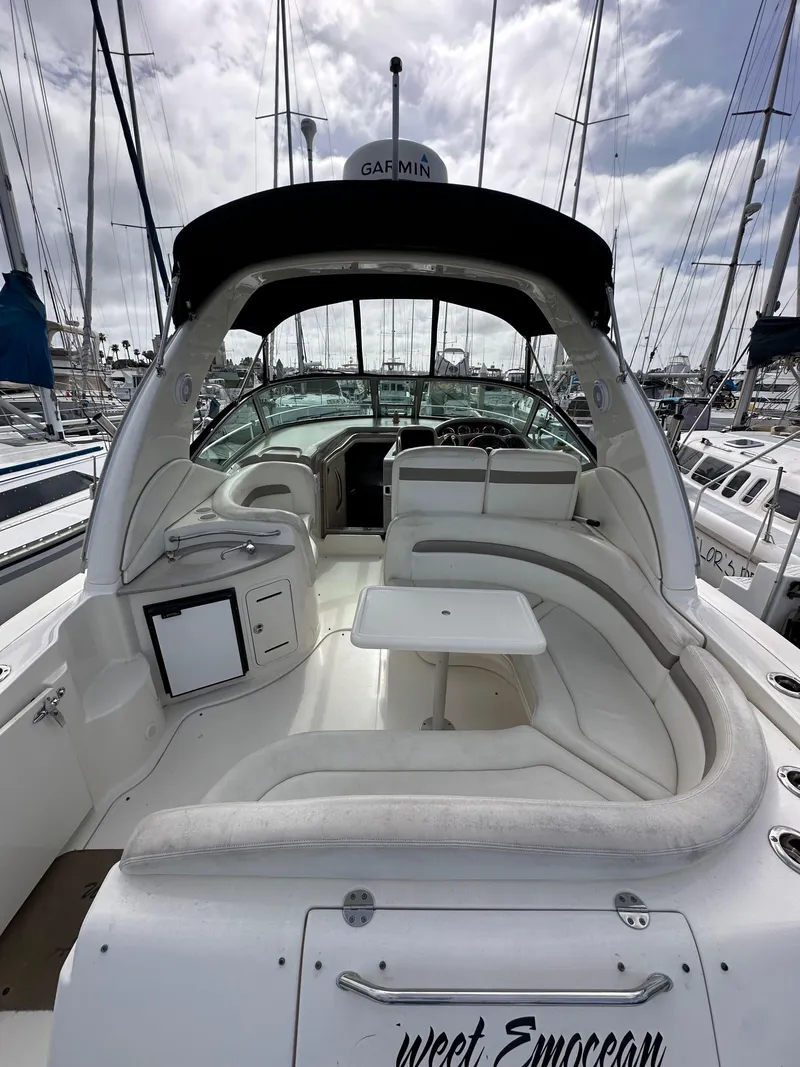 Slide: The Image of 2003 Sea Ray 320 Sundancer yacht with spacious seating and sleek design in a marina. - 9