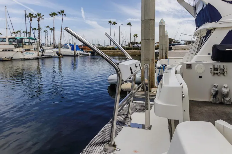 Slide: The Image of 2007 Carver 42 Super Sport yacht docked at marina with clear sky and palm trees. - 5