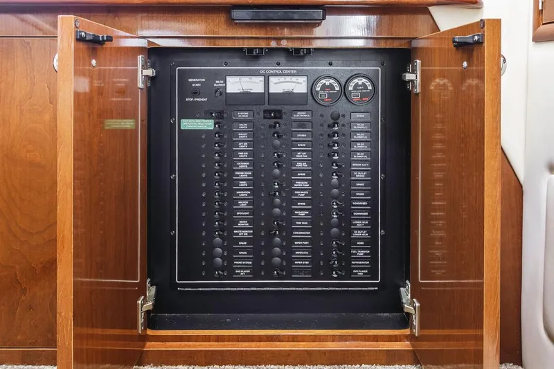 Slide: The Image of Electrical control panel inside 2007 Carver 42 Super Sport yacht, with open wooden cabinet doors. - 29