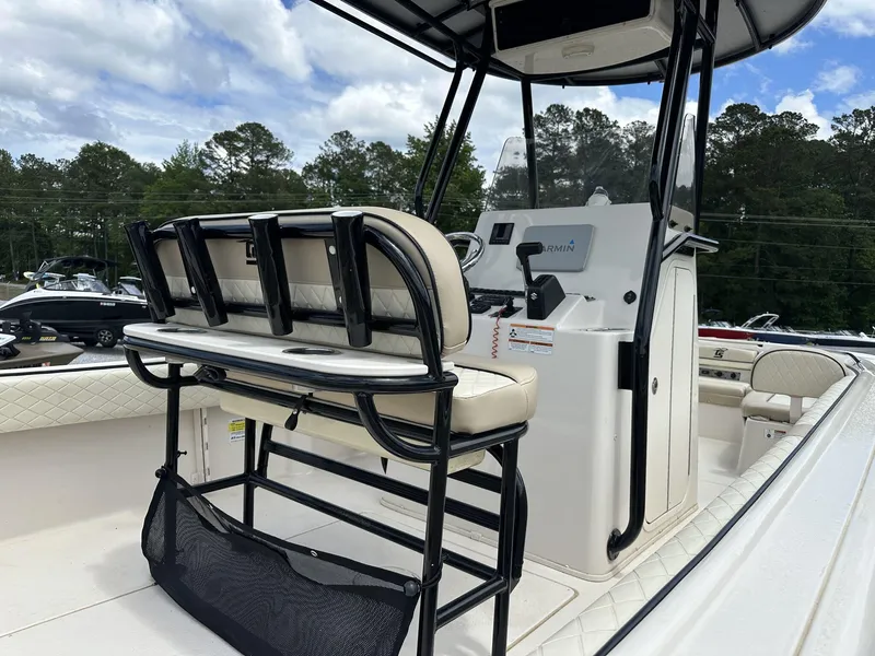 Slide: The Image of 2023 Carolina Skiff 23 Ultra Elite boat interior with seating and console, under a cloudy sky. - 10