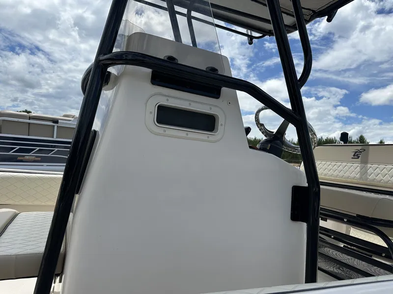 Slide: The Image of 2023 Carolina Skiff 23 Ultra Elite boat console with steering wheel under a cloudy sky. - 4