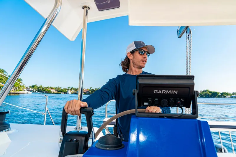 Slide: The Image of Man steering a Smart Cat S280 boat, 2025 model, on a sunny day. - 12