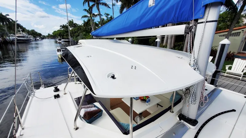 Slide: The Image of Modern Smart Cat S280 sailboat docked by a scenic waterway, featuring a sleek design and blue sail. - 24