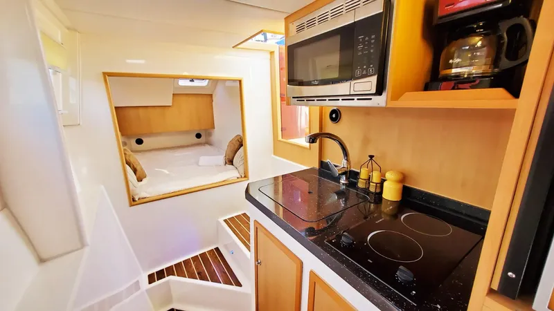 Slide: The Image of Modern kitchen interior in 2025 Smart Cat S280 yacht, featuring stove, microwave, and cozy cabin. - 30