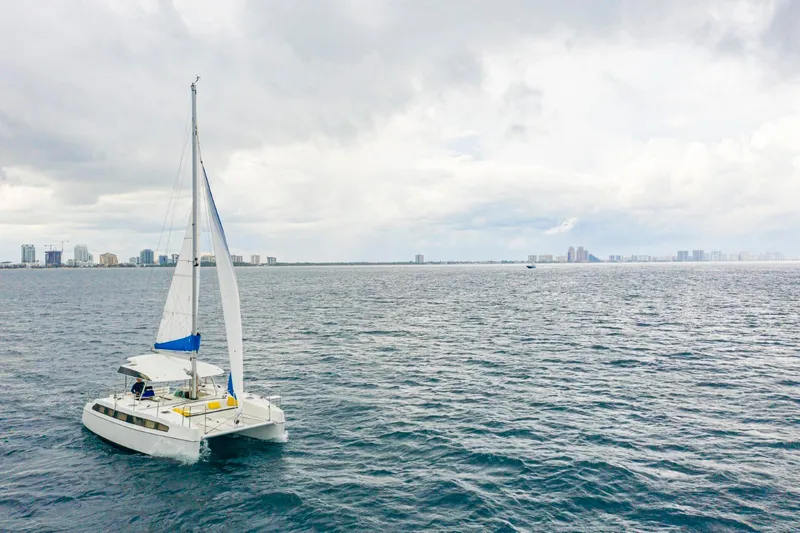 Slide: The Image of Sailing catamaran Smart Cat S280 on open sea with city skyline in background, 2025 model. - 4
