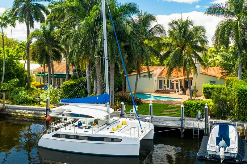Slide: The Image of Catamaran docked by tropical villa, surrounded by palm trees, featuring a Smart Cat S280, 2025 model. - 14