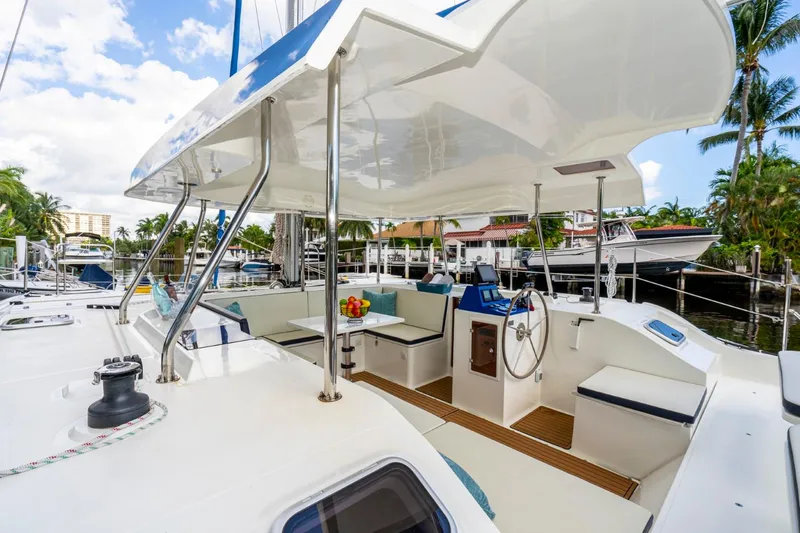 Slide: The Image of Modern Smart Cat S280 yacht interior with seating, steering wheel, and tropical marina backdrop. - 15