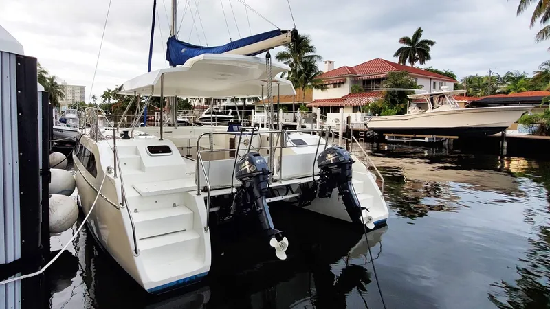 Slide: The Image of 2025 Smart Cat S280 catamaran docked in a marina, featuring dual outboard motors. - 25