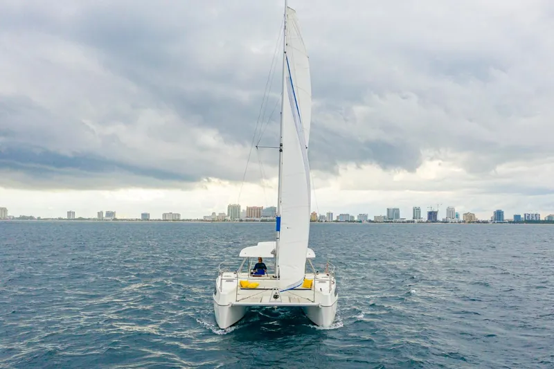 Slide: The Image of Sailing catamaran Smart Cat S280, 2025 model, on open water with city skyline. - 5