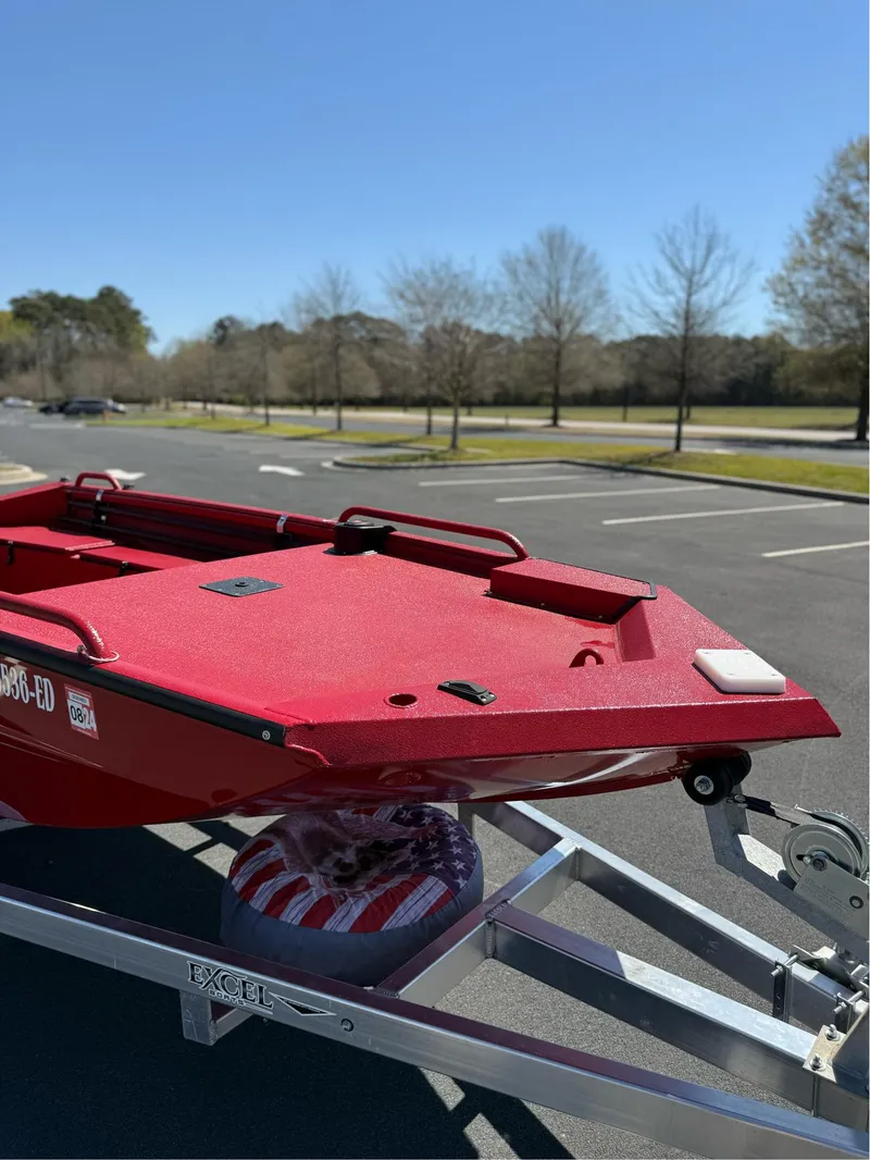 Slide: The Image of Red 2024 Excel 1751 V4 boat on trailer in sunny parking lot. - 11