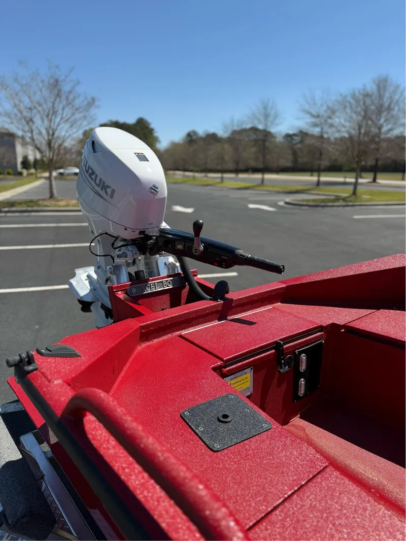 Slide: The Image of Red Excel 1751 V4 boat with Suzuki outboard motor in a parking lot, 2024 model. - 12