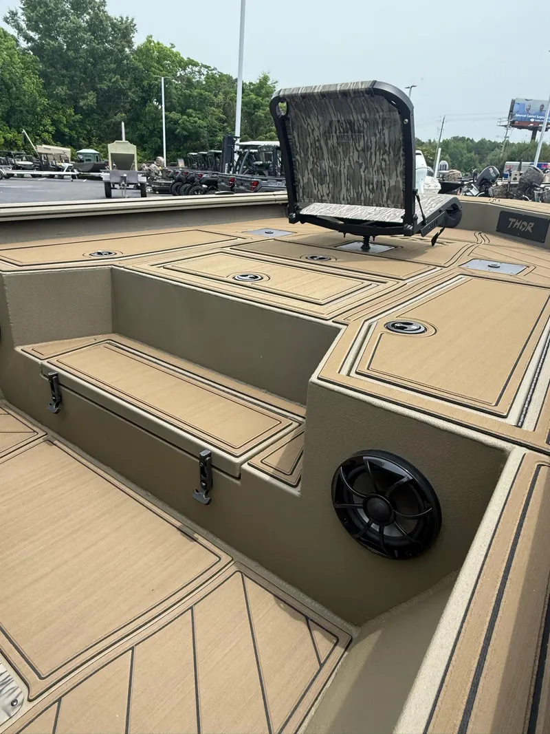 Slide: The Image of 2025 Thor Lake Hammer 1900CC boat interior with seating and speaker, featuring tan decking. - 16