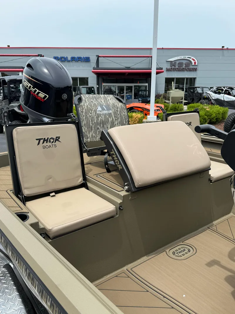 Slide: The Image of 2025 Thor Lake Hammer 1900CC boat interior with beige seats and motor, dealership background. - 18