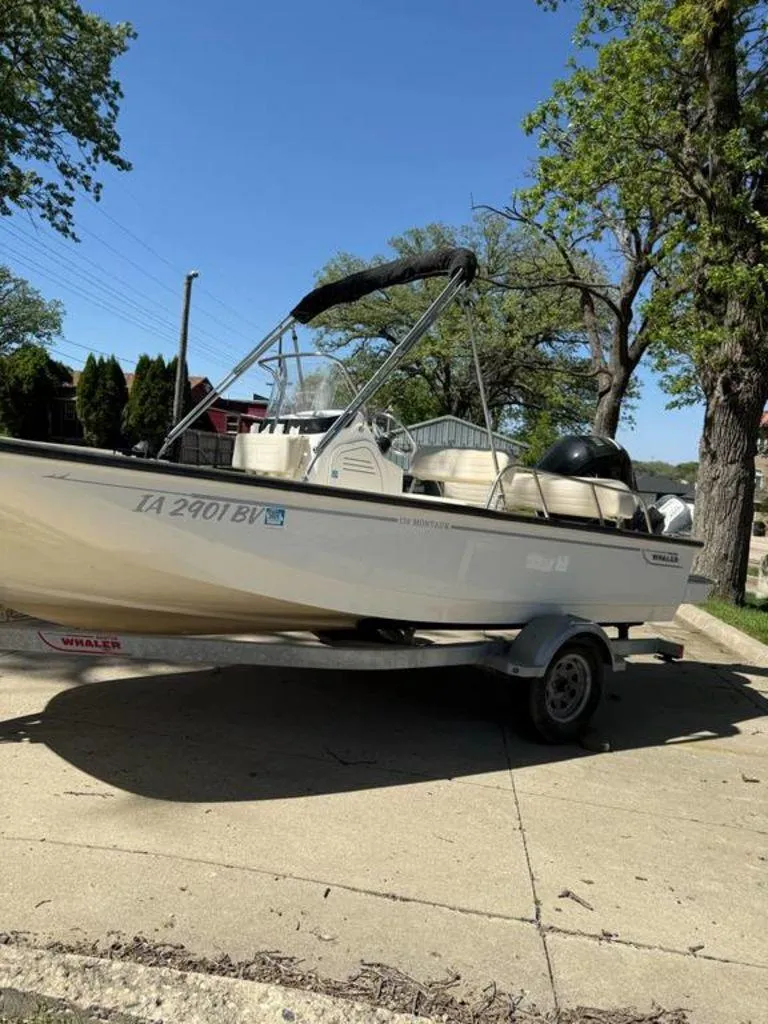 Slide: The Image of 2020 Boston Whaler 170 Montauk boat on trailer, parked on a sunny street. - 10