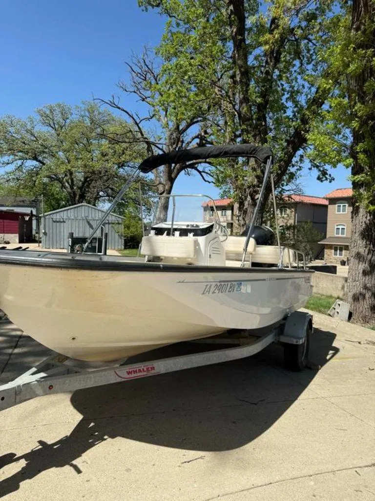 Slide: The Image of 2020 Boston Whaler 170 Montauk boat on trailer, parked outdoors under clear sky. - 2