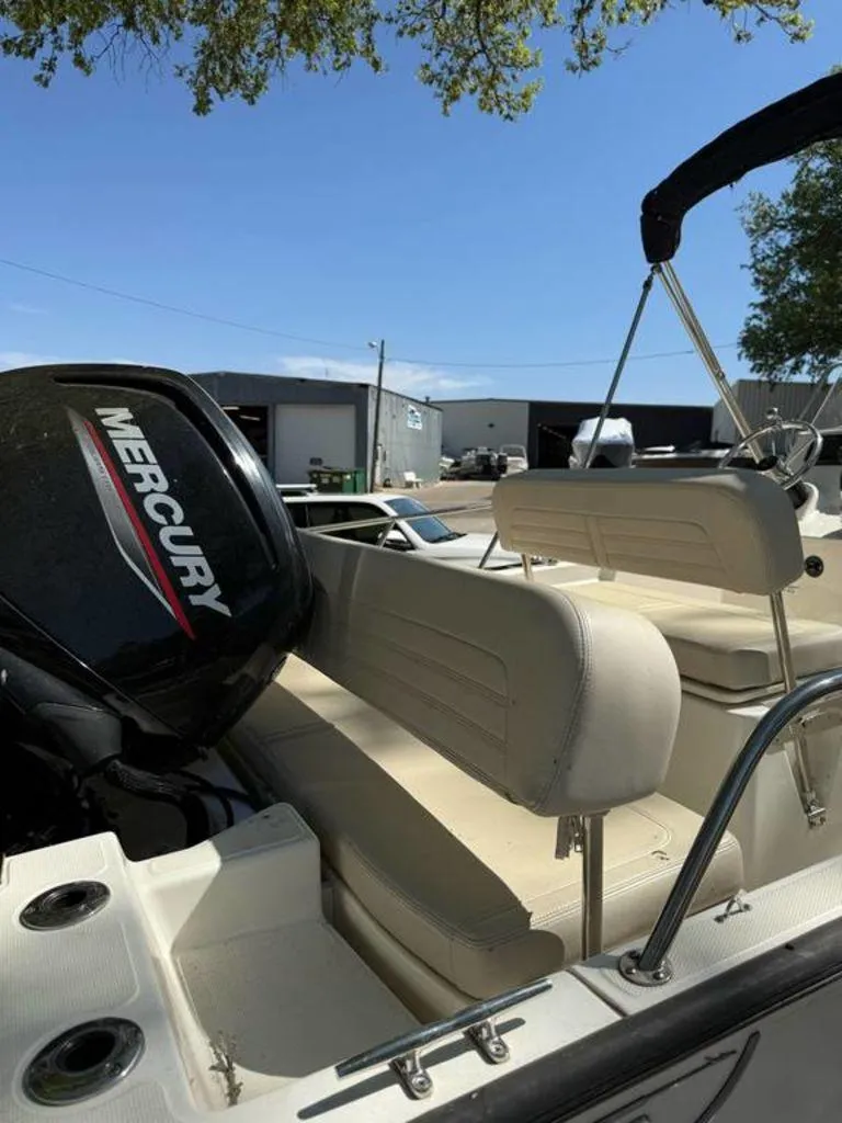 Slide: The Image of 2020 Boston Whaler 170 Montauk boat with Mercury engine, beige seating, and outdoor setting. - 7