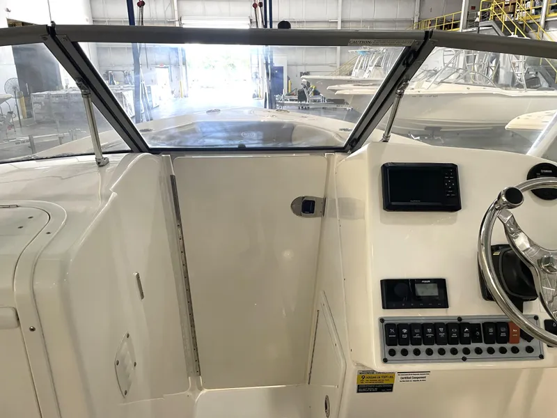 Slide: The Image of 2024 Key West 239 DFS boat dashboard with steering wheel and control panel in a showroom. - 21