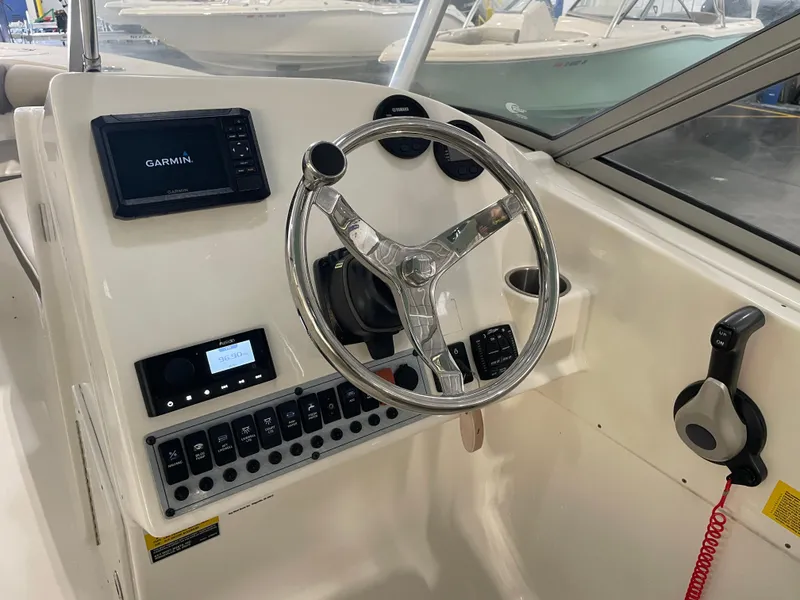 Slide: The Image of 2024 Key West 239 DFS boat dashboard with Garmin display and steering wheel. - 24