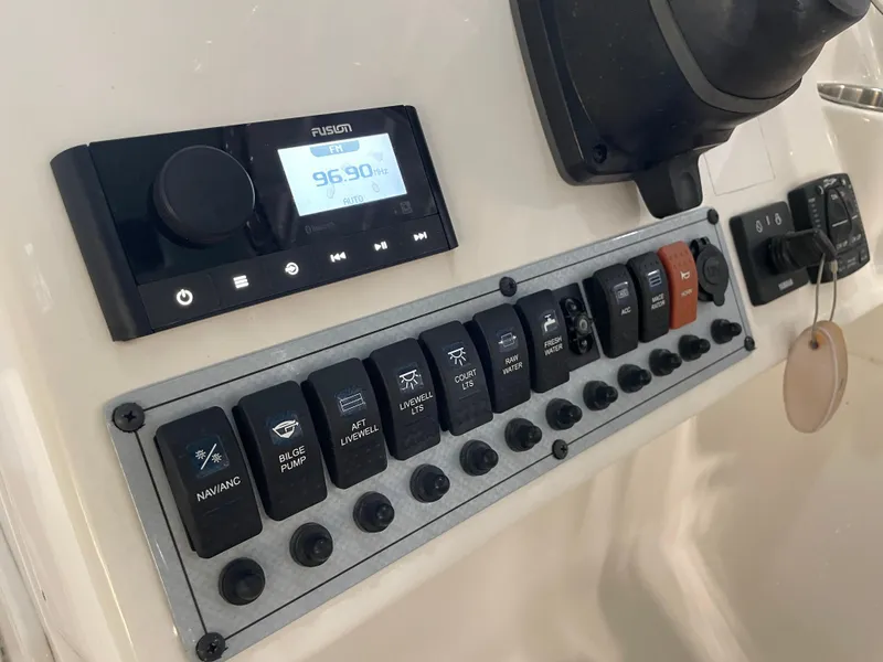 Slide: The Image of Control panel of 2024 Key West 239 DFS boat with switches and radio display. - 26