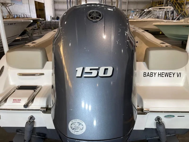 Slide: The Image of 2023 Key West 203 FS boat with 150 horsepower engine in a showroom. - 14