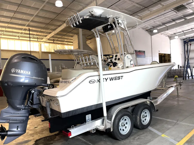 Slide: The Image of 2023 Key West 203 FS boat on trailer with Yamaha outboard in a warehouse. - 2