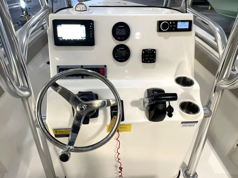 Slide: The Image of 2023 Key West 203 FS boat console with steering wheel, gauges, and controls. - 24