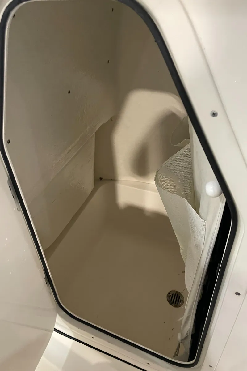 Slide: The Image of Storage compartment inside 2023 Key West 203 FS boat, featuring a drain and white interior. - 31