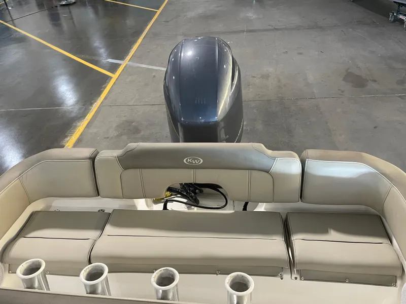 Slide: The Image of 2023 Key West 203 FS boat interior with cushioned seating and motor in a showroom. - 33
