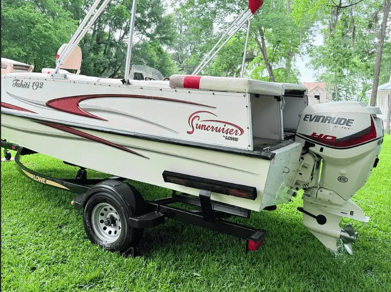 Slide: The Image of 2005 Lowe Suncruiser boat with Evinrude motor on grassy lawn. - 1