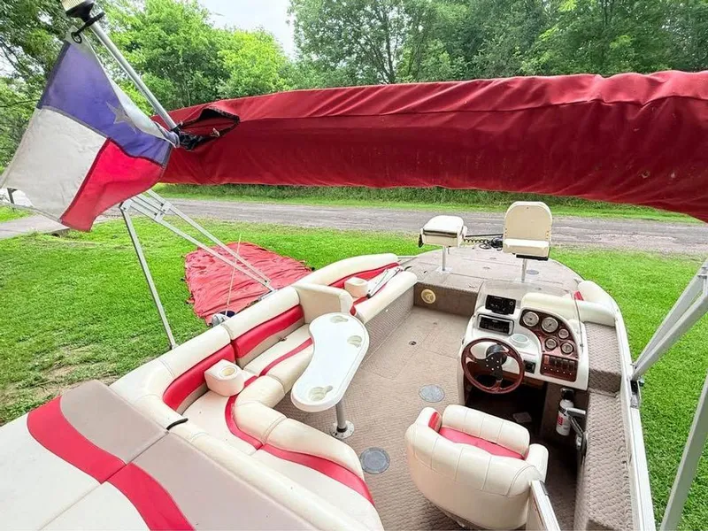 Slide: The Image of 2005 Lowe Suncruiser boat interior with red and white seating, steering console, and canopy. - 10