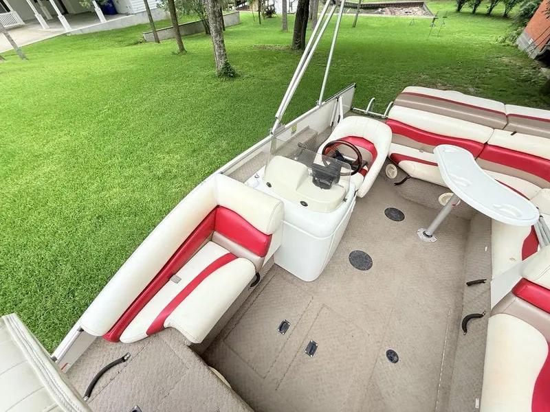 Slide: The Image of 2005 Lowe Suncruiser pontoon boat with red and white seating, steering console, and table. - 14