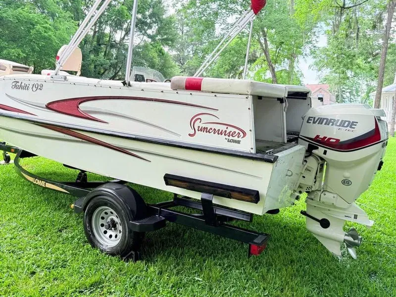 Slide: The Image of 2005 Lowe Suncruiser boat with Evinrude motor on a trailer, parked on grass. - 15
