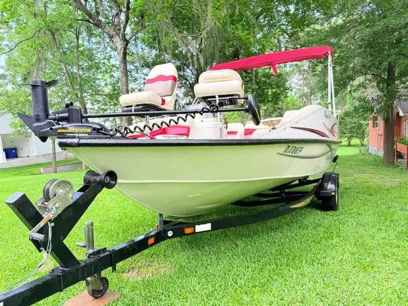 Slide: The Image of 2005 Lowe Suncruiser boat on trailer, parked on grass with trees in background. - 3