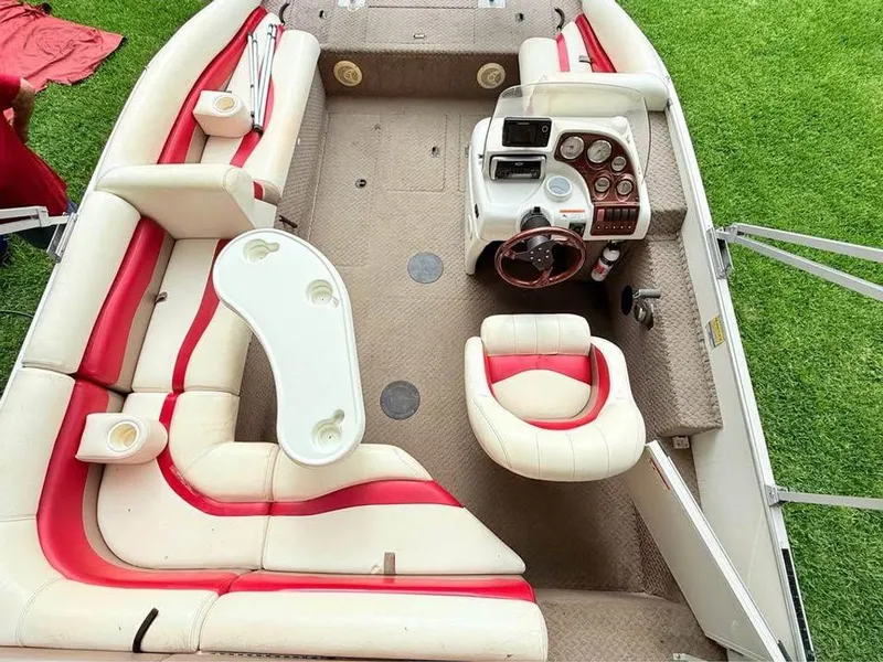Slide: The Image of 2005 Lowe Suncruiser boat interior with red and white seating, steering console, and table. - 6