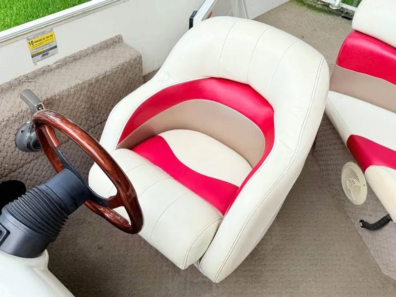 Slide: The Image of 2005 Lowe Suncruiser boat seat with red and white upholstery, wooden steering wheel. - 7