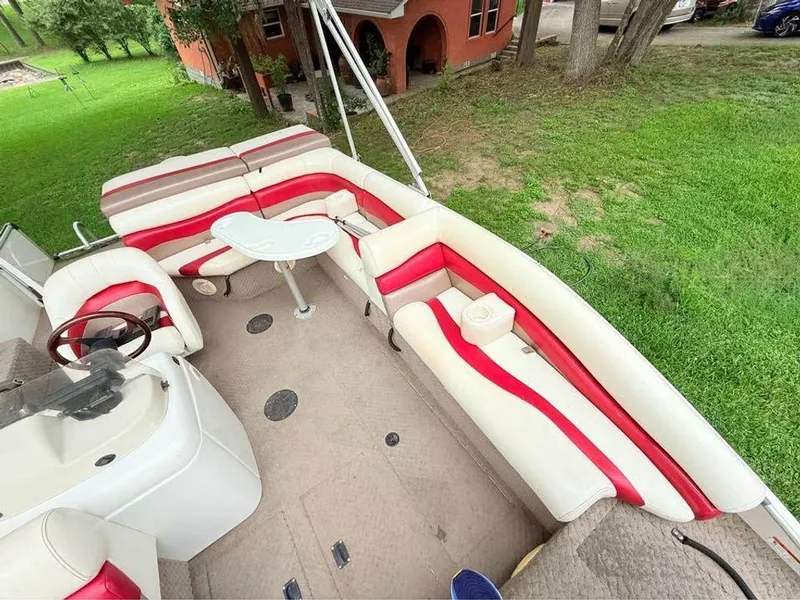 Slide: The Image of 2005 Lowe Suncruiser boat interior with red and white seating, outdoor setting. - 9