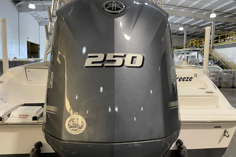 Slide: The Image of 2023 Key West 239 DFS boat interior with modern dashboard and seating in a warehouse. - 16