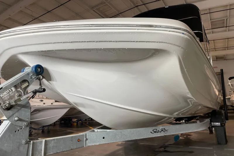 Slide: The Image of 2022 Hurricane SunDeck Sport 201 OB boat with black canopy under clear blue sky. - 11